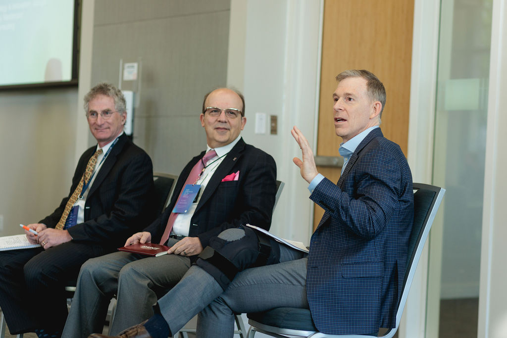 three panelists seated on stage