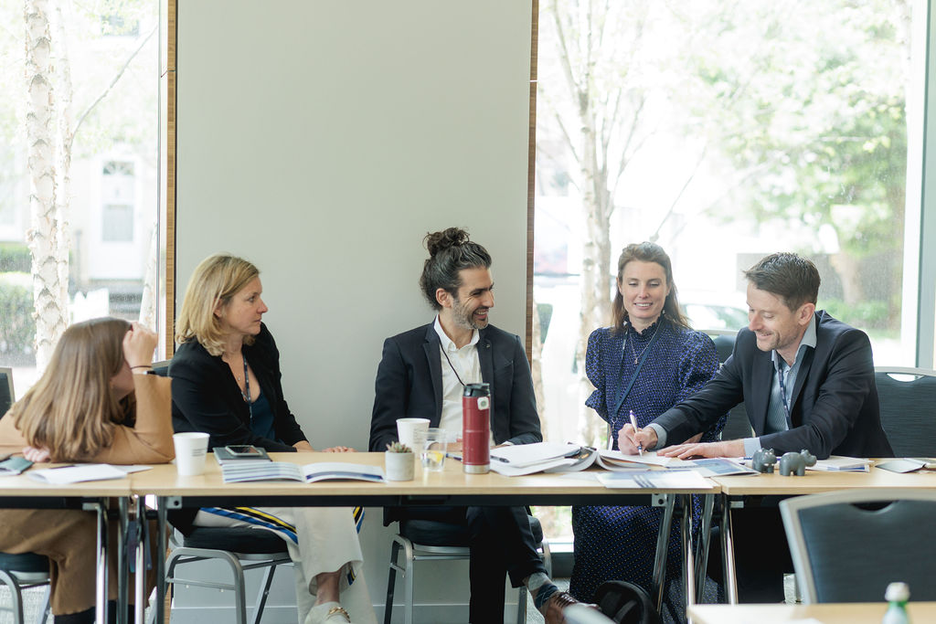 people speaking and writing at a table