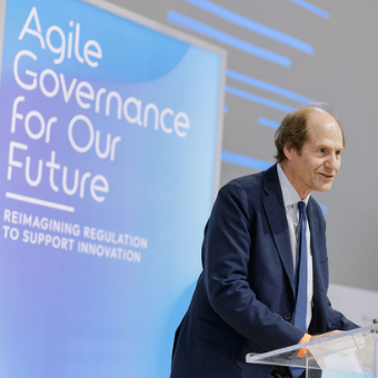 Cass Sunstein speaking behind a lectern on stage