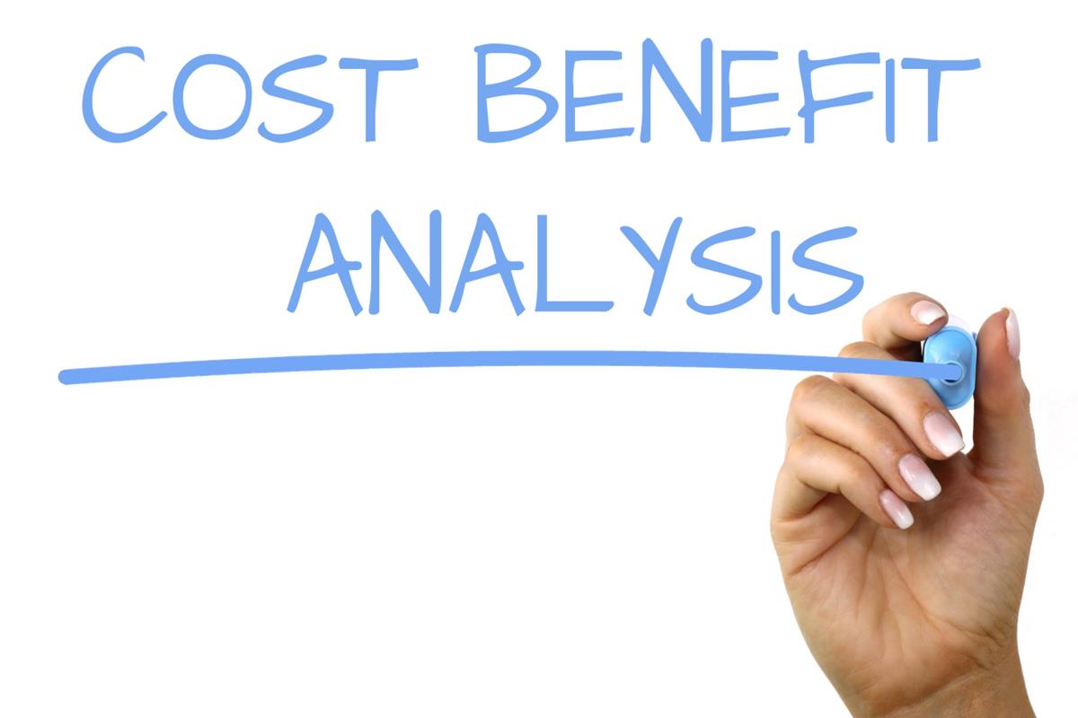 Hand writing the words "cost benefit analysis" in blue marker