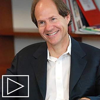 Photo of Cass Sunstein in seated in front of a bookshelf.