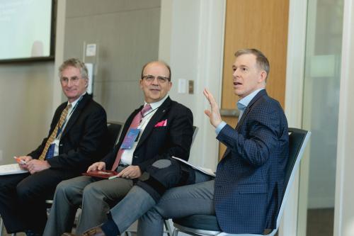 three panelists seated on stage