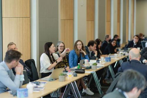 people speaking while seated at tables