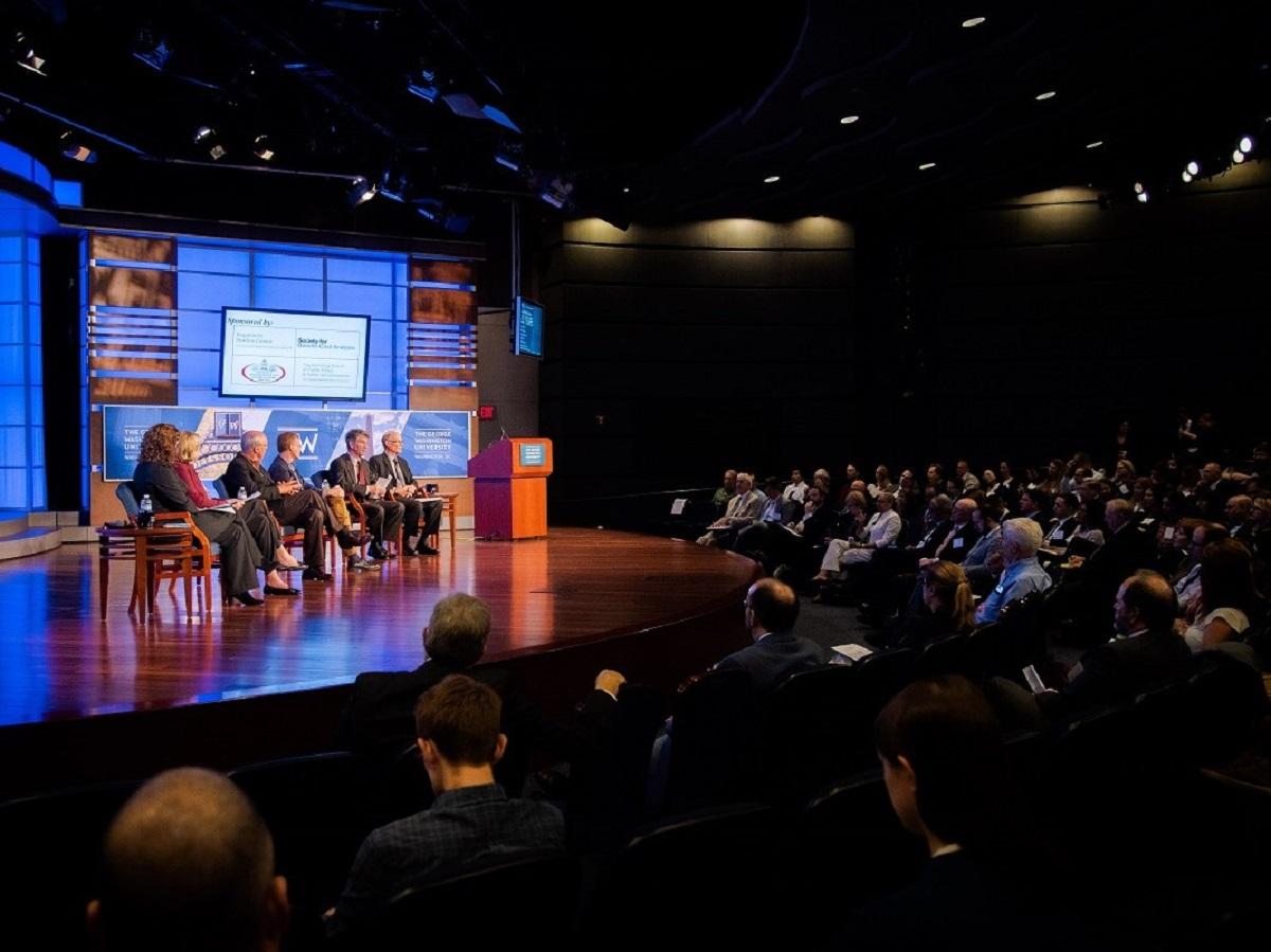 Panel One participants on stage in the Jack Morton Auditorium with the audience visible