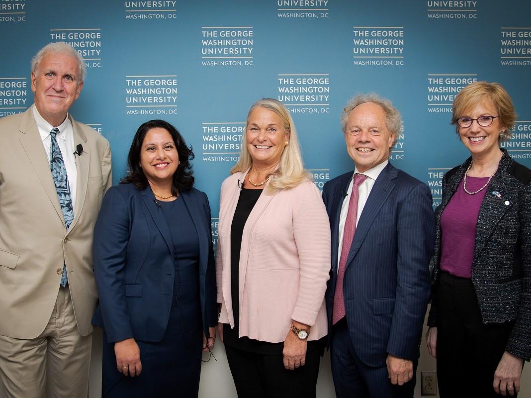 Panel Three participants standing in front of a GW banner.
